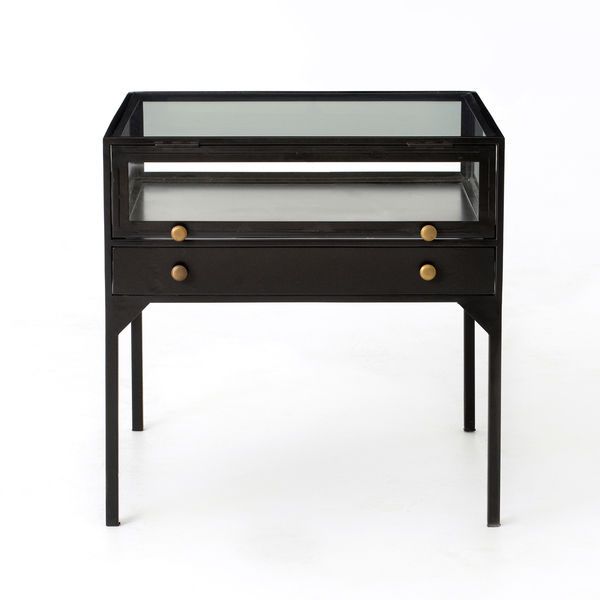 Showcase your favorite collectibles with the Shadow Box End Table, featuring a glass enclosure and matte-black metal frame with brass knobs. Perfect for adding a unique, stylish touch to your living room decor.