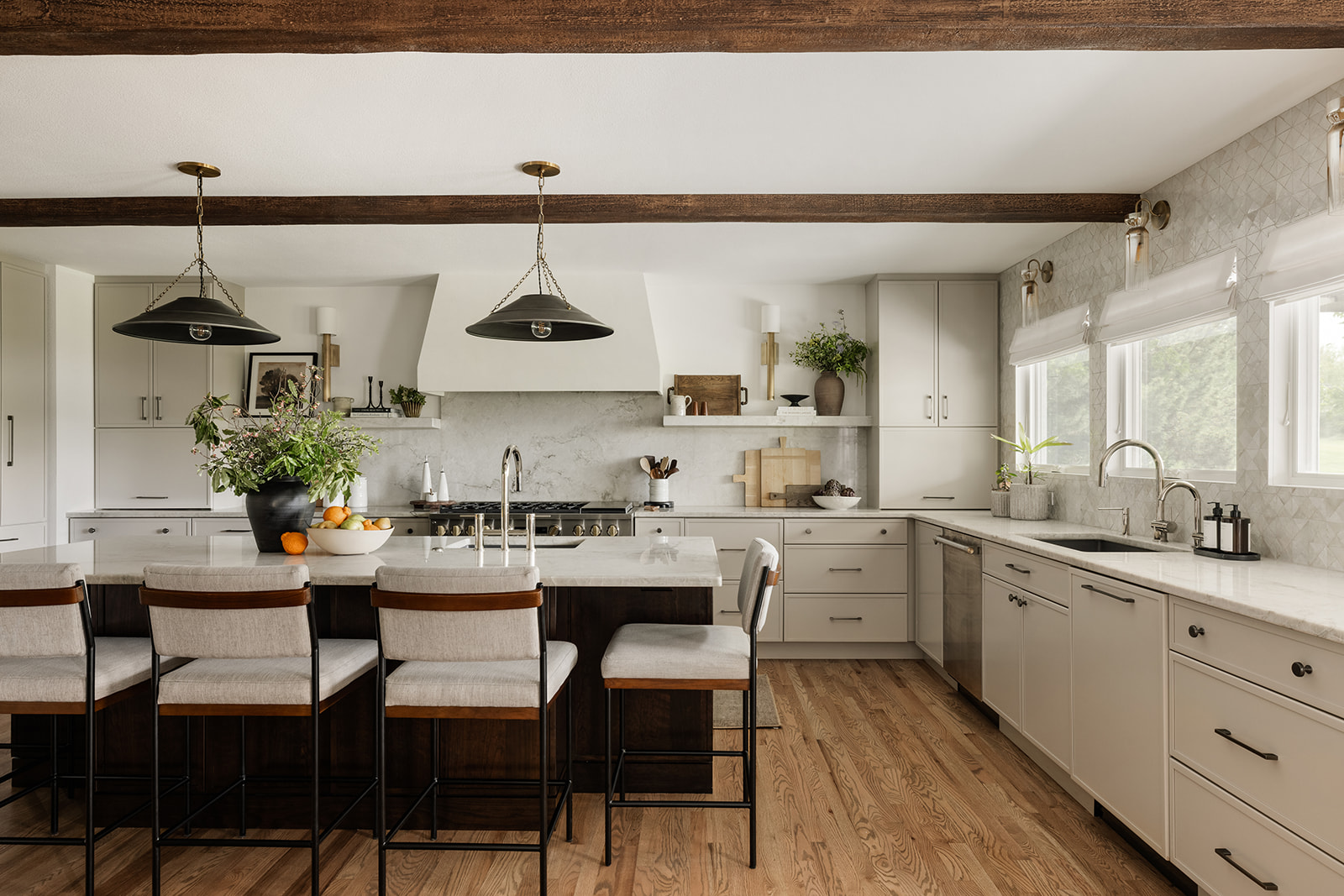 Dreaming of a kitchen that feels both warm and modern? Tour this Rustic Contemporary Kitchen filled with organic materials, a large island with seating for five, a custom plaster range hood, and a beautiful mix of modern and natural textures. See how we balanced form and function with layered lighting, durable finishes, and smart layout ideas.